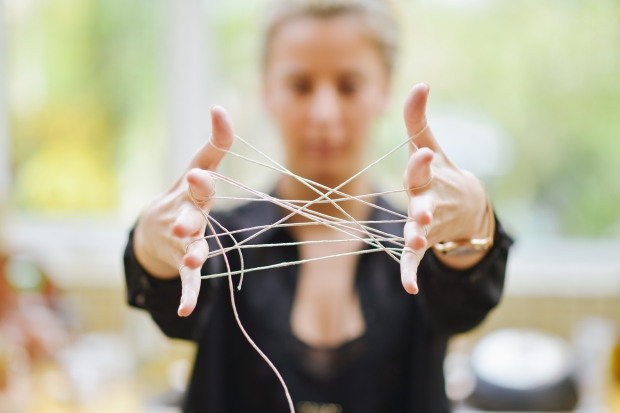 womans-hands-connected-with-tangled-string